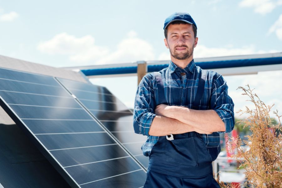 Solar panel installer standing on solar roof